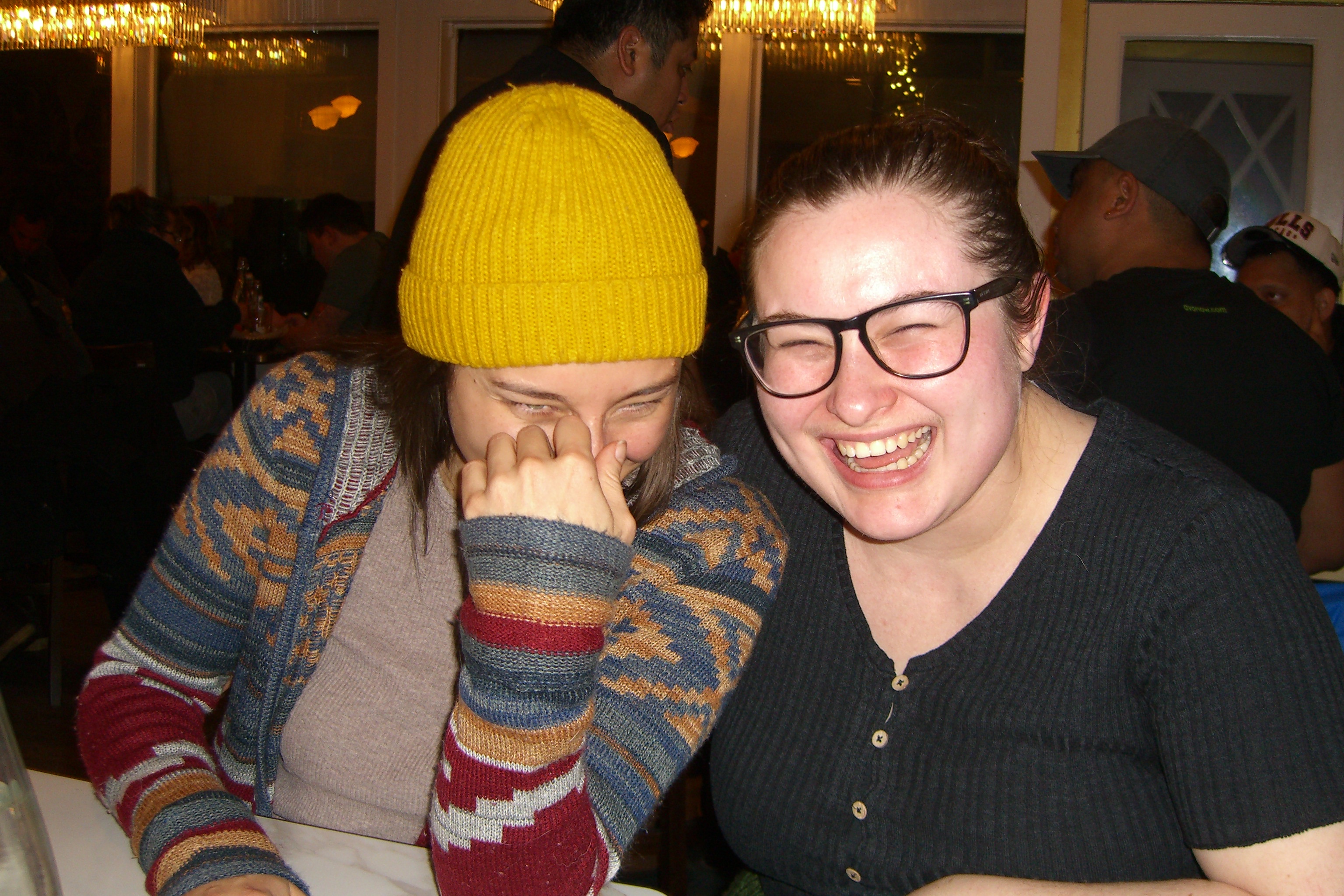 Two friends laughing at a restaurant