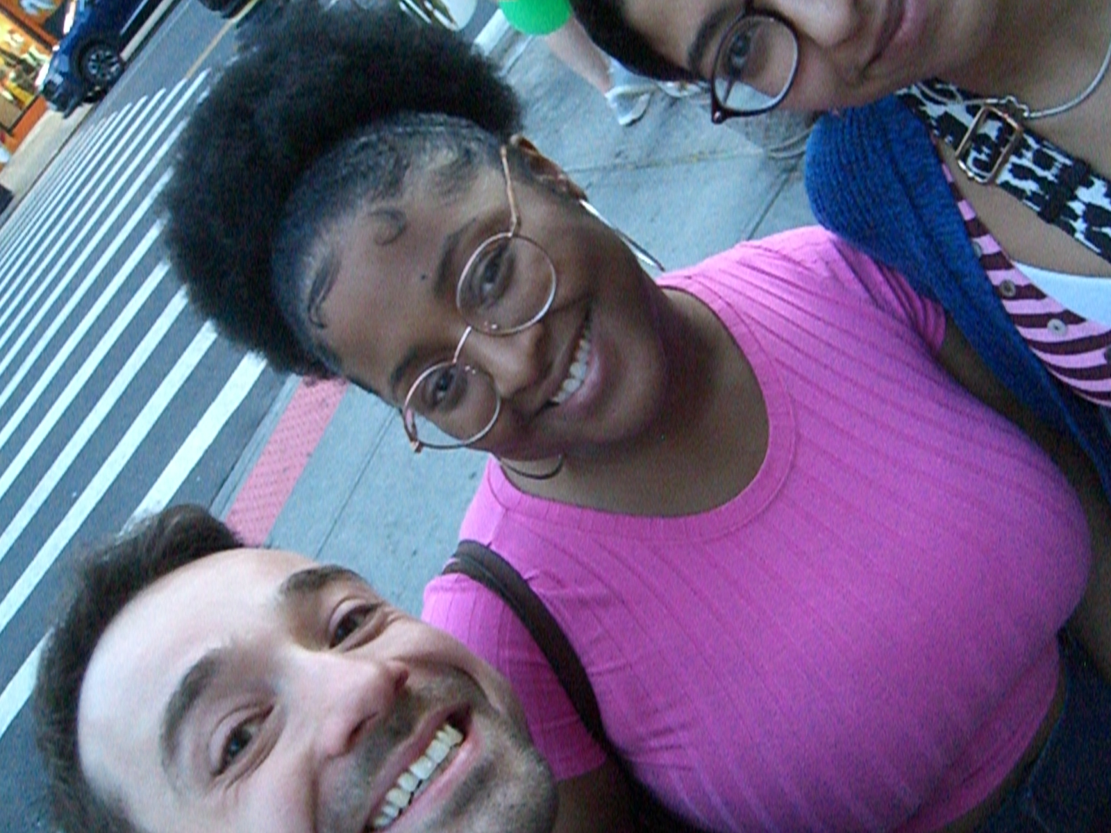 Three people taking a selfie on a city sidewalk